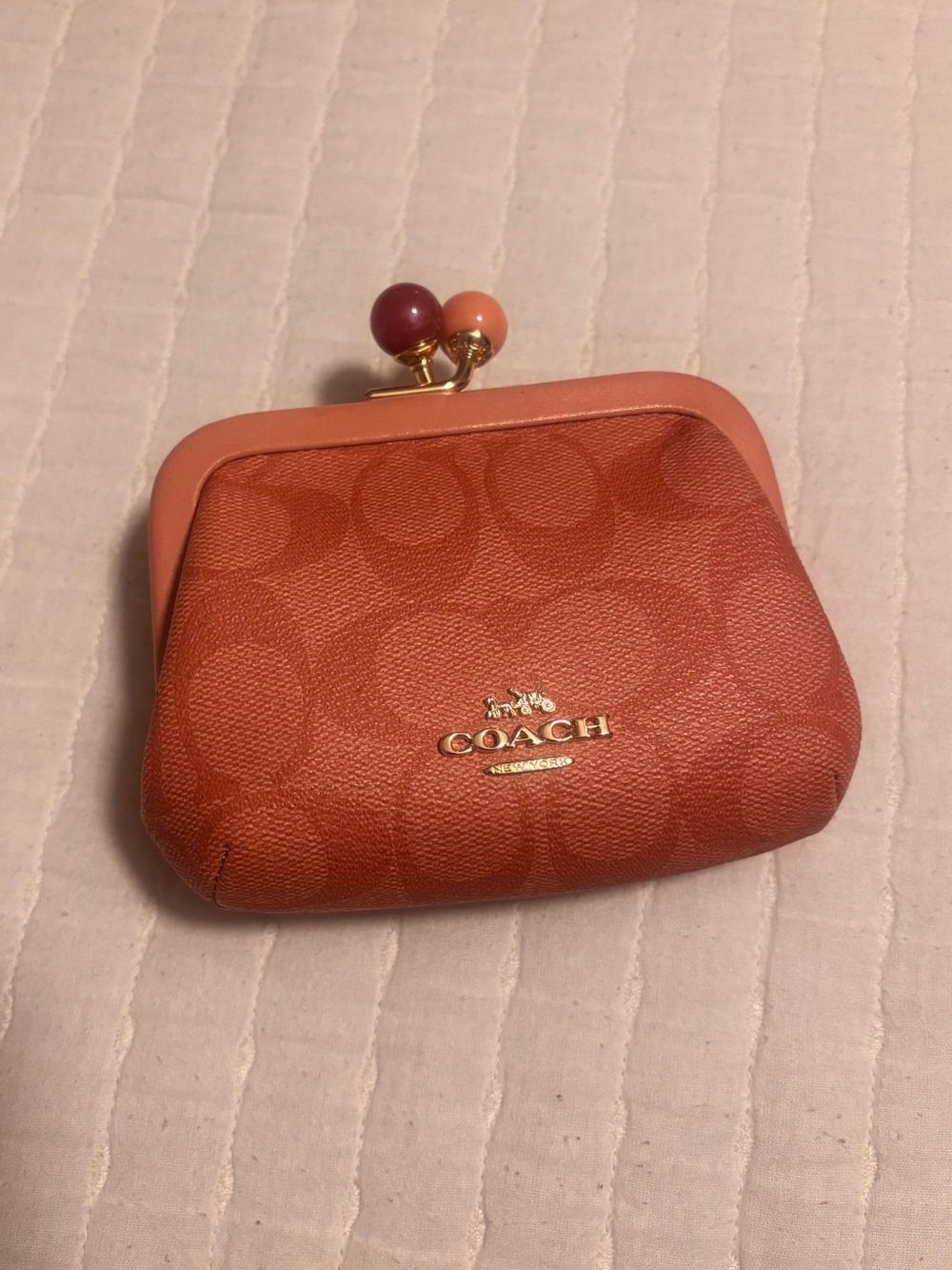 Coach women’s Nora Coral Signature canvas Kiss-Lock Coin Purse